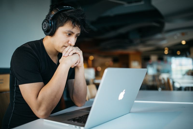 Jonge man geconcentreerd achter zijn notebook